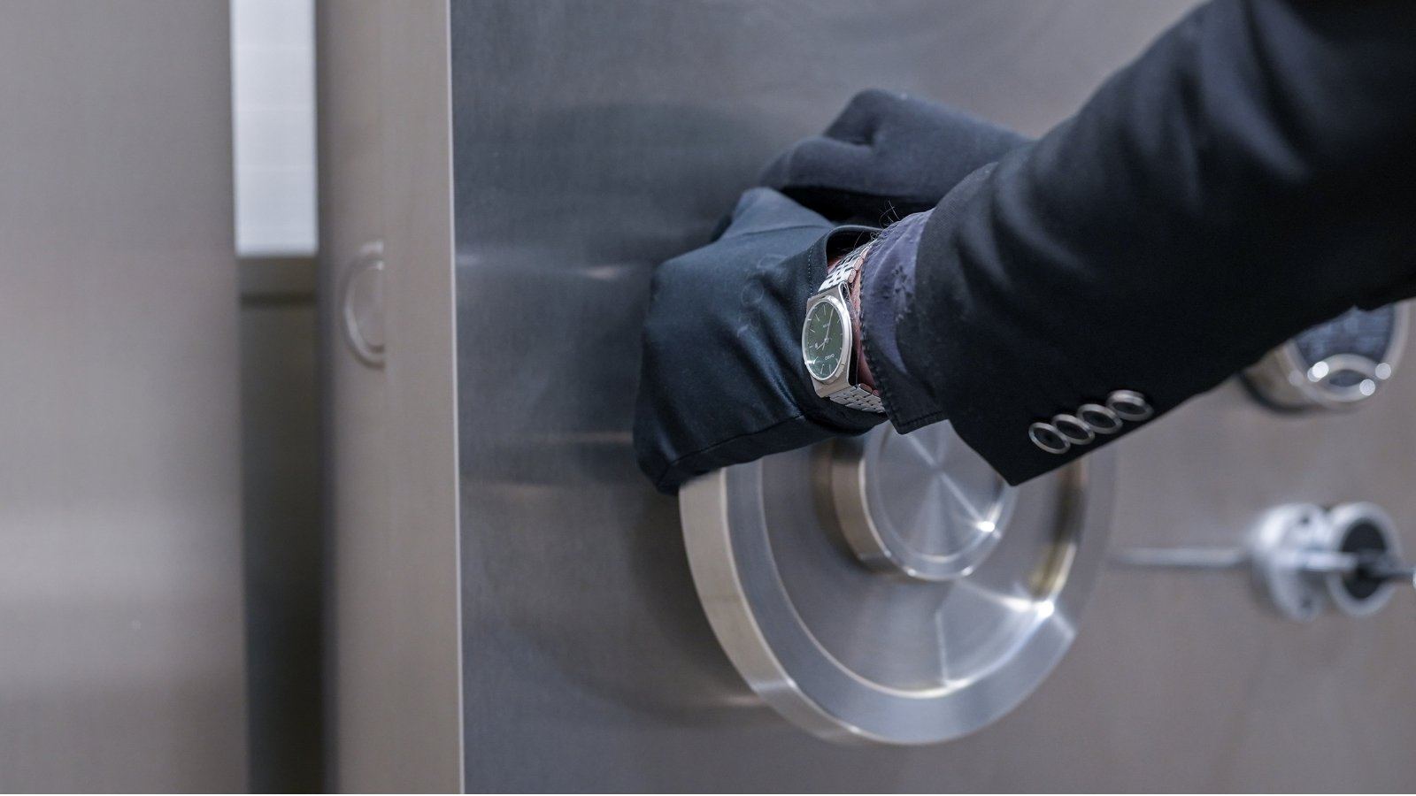 Dual-key vault door mechanism operated by a gloved Amanat Vaults attendant